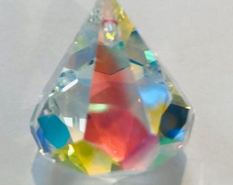 May include: A clear crystal teardrop prism with iridescent rainbow colors. The prism is faceted and has a hole at the top for hanging.