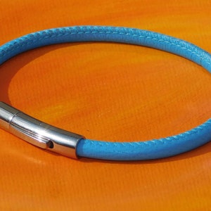 May include: A light blue leather bracelet with a silver clasp.
