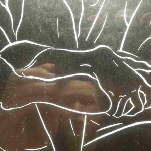May include: A black and white line drawing of hands holding each other. The image has a reflective surface, with white lines outlining the hands and arms. The style is simple and elegant, suggesting a theme of connection or support.