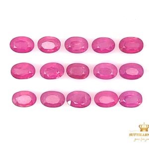 May include: A collection of 15 oval-shaped pink gemstones, arranged in three rows of five. The gemstones are all approximately the same size and shape.