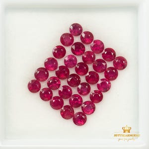 Pode incluir: Uma coleção de vinte e cinco rubis redondos, facetados e de um vermelho rosado profundo, dispostos num padrão de grelha em forma de diamante. As gemas são exibidas num tabuleiro quadrado branco com o texto SUTTIKARNGEMS gems for jewelry.
