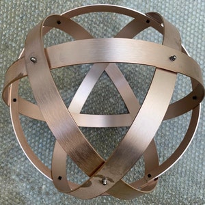 Genesa Crystal in pink brushed aluminum 32 cm in diameter bands 30 mm wide twisted symmetrically fastened with gray blind nuts