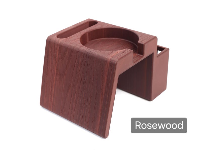 Puede incluir: Soporte de madera color palisandro con una hendidura circular y una ranura rectangular. El soporte tiene un dise&ntilde;o moderno con una base robusta y un peque&ntilde;o compartimento lateral. La palabra "Rosewood" se muestra en un rect&aacute;ngulo gris.