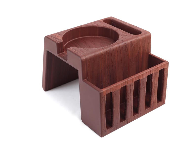 Puede incluir: Una estaci&oacute;n de caf&eacute; espresso de madera de color marr&oacute;n oscuro. Cuenta con una hendidura circular, una ranura rectangular y un compartimento ranurado. El dise&ntilde;o es moderno y minimalista, adecuado para uso dom&eacute;stico o de oficina.