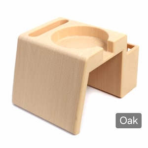 Puede incluir: Un organizador de escritorio de madera de color roble claro con una hendidura circular, una ranura y un peque&ntilde;o compartimento rectangular. La palabra "Oak" est&aacute; en un cuadro gris en la esquina inferior derecha.