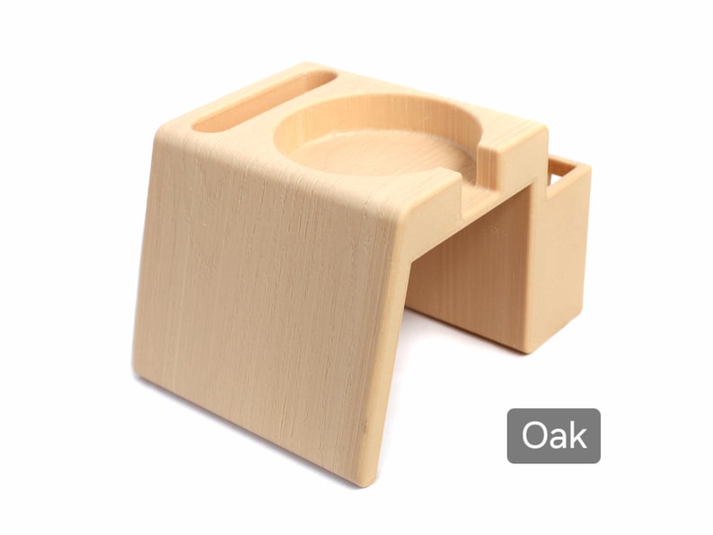 Puede incluir: Un organizador de escritorio de madera de color roble claro con una hendidura circular, una ranura y un peque&ntilde;o compartimento rectangular. La palabra "Oak" est&aacute; en un cuadro gris en la esquina inferior derecha.