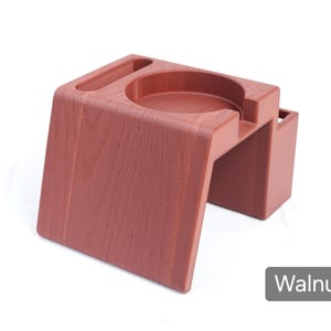 Puede incluir: Un organizador de escritorio color nogal con un portavasos y una ranura peque&ntilde;a. El organizador tiene una textura de vetas de madera y un dise&ntilde;o moderno. La palabra "Walnut" est&aacute; impresa abajo a la derecha.