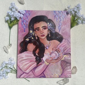 May include: A painting of a woman with long dark hair wearing a pink dress and holding a pearl in her hands. She is surrounded by purple and white flowers and has a delicate gold necklace on.