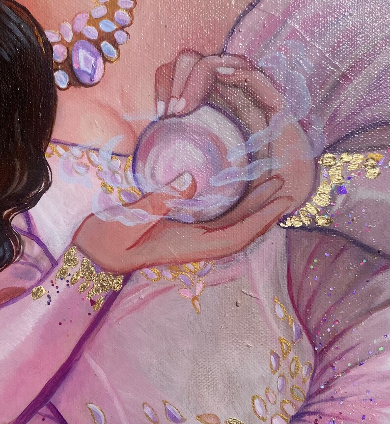 May include: A close-up of a hand holding a small, round, purple orb. The orb is surrounded by a white, wispy smoke. The hand is wearing a pink and gold bracelet.