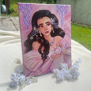 May include: A painting of a woman with long dark hair wearing a pink dress and holding a pearl. She is surrounded by a purple and pink background with a floral design.
