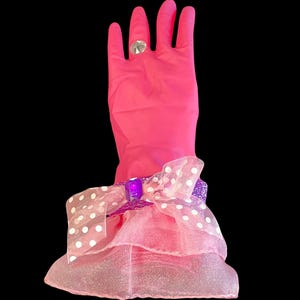 Pink dish washing gloves decorated with a light pink organza skirt, accent ribbon band around the wrist with a jewel on top, and completed with bling diamond ring. Valentine Favorite.