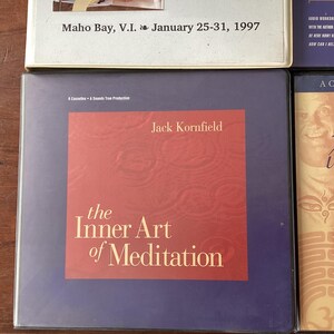 May include: A purple and red book cover with the title "The Inner Art of Meditation" by Jack Kornfield. The book cover has a textured background.