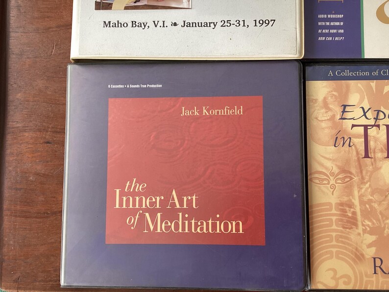 May include: A purple and red book cover with the title "The Inner Art of Meditation" by Jack Kornfield. The book cover has a textured background.