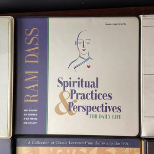 May include: A collection of audio cassette tapes featuring lectures by Ram Dass on spiritual practices and perspectives for daily life. The tapes are titled "Spiritual Practices & Perspectives for Daily Life" and feature a drawing of a person with their eyes closed and a heart in the center of their chest.