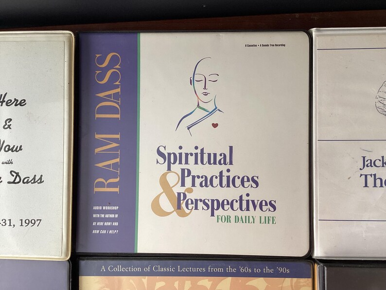 May include: A collection of audio cassette tapes featuring lectures by Ram Dass on spiritual practices and perspectives for daily life. The tapes are titled "Spiritual Practices & Perspectives for Daily Life" and feature a drawing of a person with their eyes closed and a heart in the center of their chest.