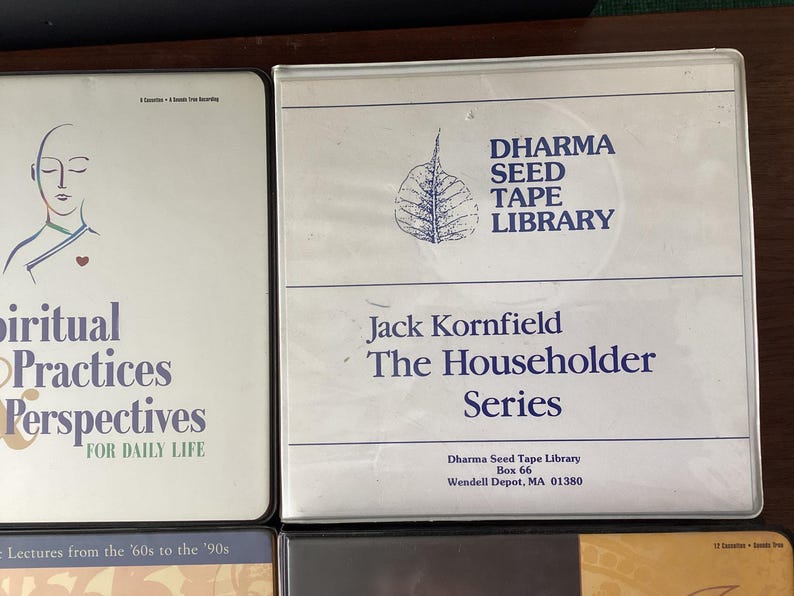 May include: Three cassette tapes with white labels and black text. The first tape is titled "Spiritual Practices & Perspectives for Daily Life" and features a drawing of a person with their eyes closed. The second tape is titled "Dharma Seed Tape Library Jack Kornfield The Householder Series" and features a drawing of a leaf. The third tape is titled "12 Sessions - Sanity Path".