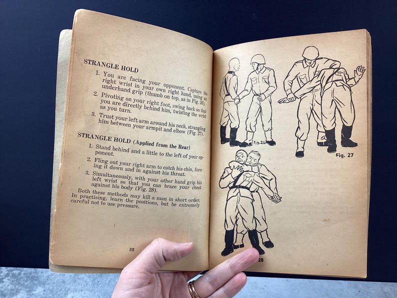 May include: Open book with illustrations and text on self-defense techniques. The pages are aged with text and diagrams showing various strangle holds. The book is open, revealing the illustrations.