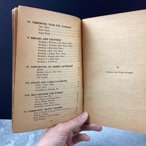 May include: Open vintage book pages with a table of contents on self-defense techniques. Sections include throwing, breaks, counters, thwarting armed adversaries, police tactics, and self-defense for women. The text "Science over brute strength" is visible.