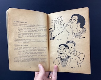 May include: Open book with illustrations and text on self-defense techniques. The illustrations show figures demonstrating hand strikes and ear boxing. The text includes instructions on how to perform the techniques.