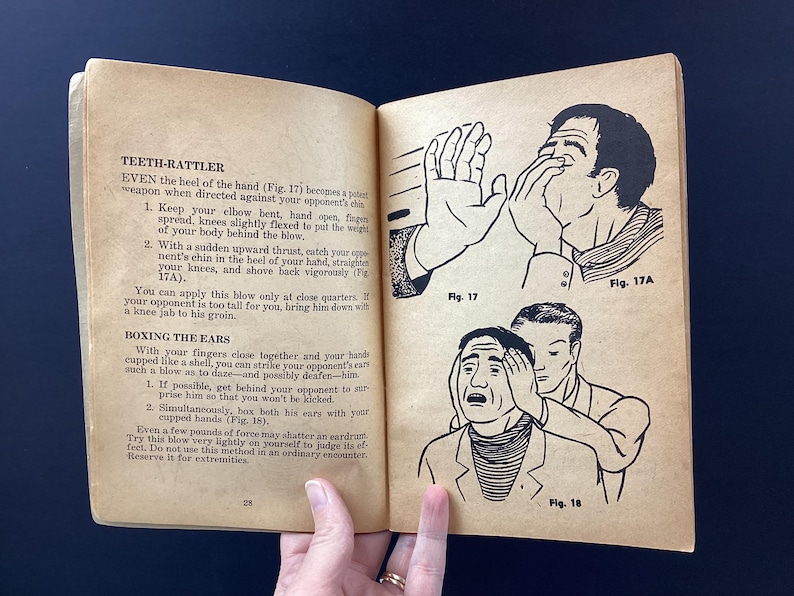 May include: Open book with illustrations and text on self-defense techniques. The illustrations show figures demonstrating hand strikes and ear boxing. The text includes instructions on how to perform the techniques.