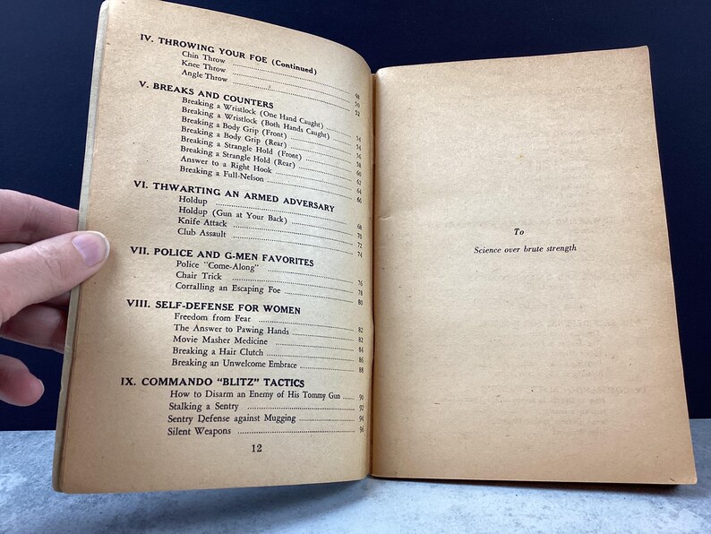 May include: Open vintage book pages with text on self-defense techniques. Sections include "Throwing Your Foe," "Breaks and Counters," and "Self-Defense for Women." The text is accompanied by page numbers and the phrase "Science over brute strength."