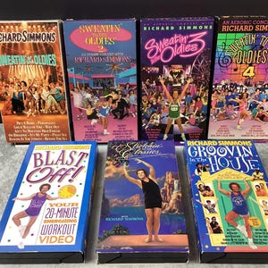 Puede incluir: Una colección de cintas VHS de Richard Simmons, con títulos como "Sweatin' to the Oldies" y "Blast Off!". Las cintas muestran gráficos coloridos e imágenes de Simmons dirigiendo rutinas de ejercicios. Las cintas están en su embalaje original.