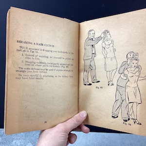 May include: Open book page with illustrations and text about self-defense techniques. The text reads "BREAKING A HAIR CLUTCH" with instructions and diagrams. Figures 95 and 96 show step-by-step actions.