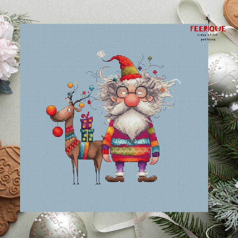 May include: A cross stitch pattern featuring a whimsical Santa Claus with a long white beard and a reindeer with a red nose. Santa is wearing a colorful sweater and a red hat. The reindeer is carrying a stack of presents. The pattern is on a light blue background.