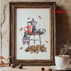 May include: Cross-stitch art in a wooden frame depicts a whimsical autumn scene. A small table holds a coffee pot, a red mug with "COFFEE" on it, and a sleeping bunny. A bat hangs upside down. Fallen leaves surround the table.