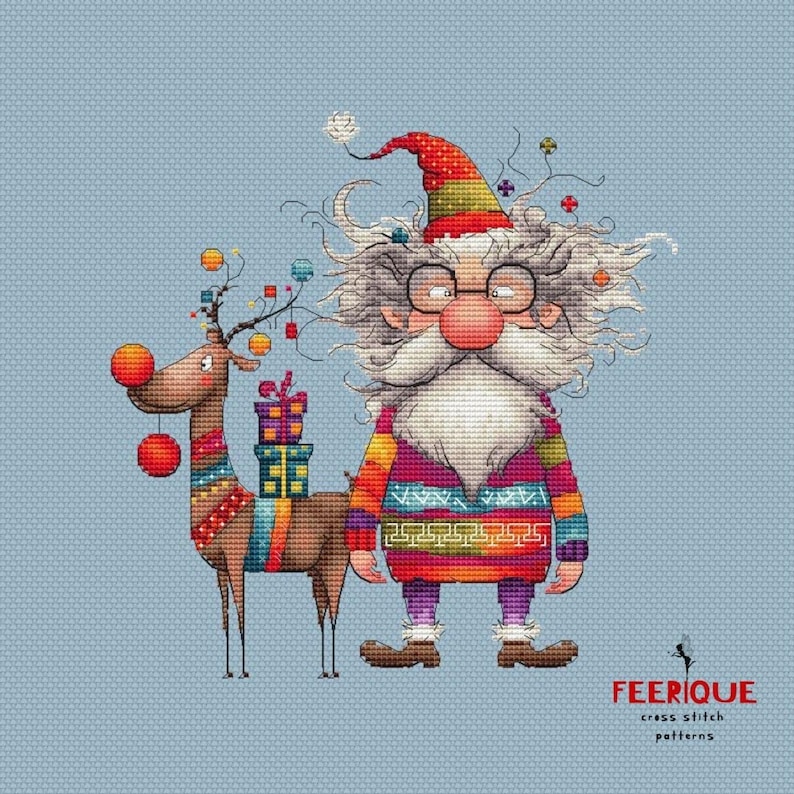 May include: A cross stitch pattern featuring a whimsical Santa Claus with a long white beard and a red hat, holding a gift box. He is standing next to a reindeer with red and orange ornaments. The background is a light blue color. The text "FEERIQUE cross stitch patterns" is at the bottom of the image.