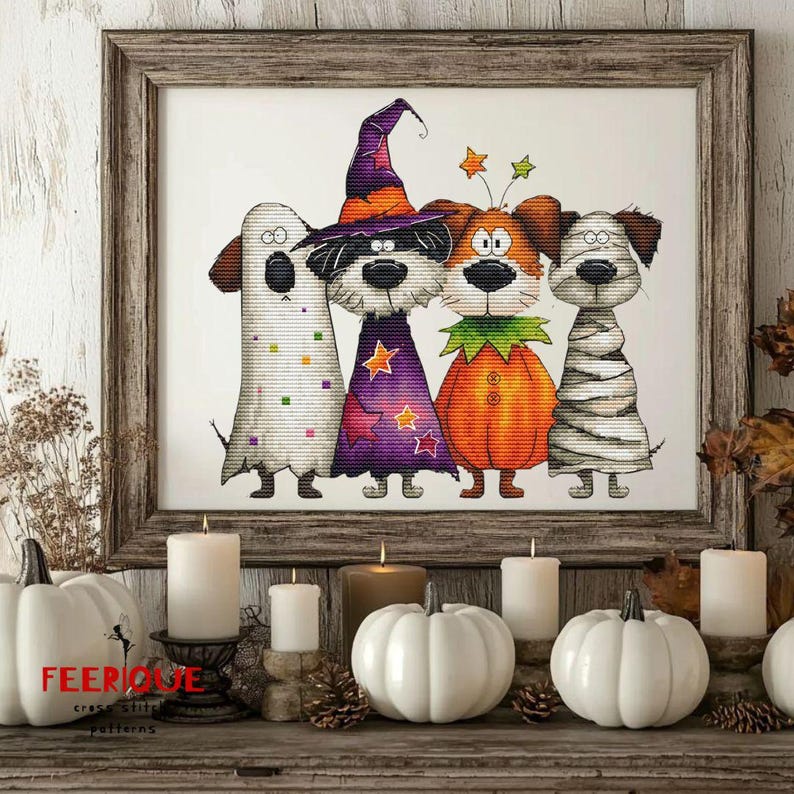 Puede incluir: Un bordado de punto de cruz enmarcado con cuatro perros disfrazados para Halloween: un fantasma, una bruja, una calabaza y una momia. La obra de arte est&aacute; enmarcada en un marco de madera r&uacute;stico. Calabazas blancas y velas en primer plano.