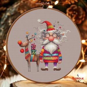 May include: A cross stitch pattern featuring a whimsical Santa Claus with a long white beard and glasses, wearing a colorful sweater and holding a gift. A reindeer with red ornaments and a gift is standing next to him.