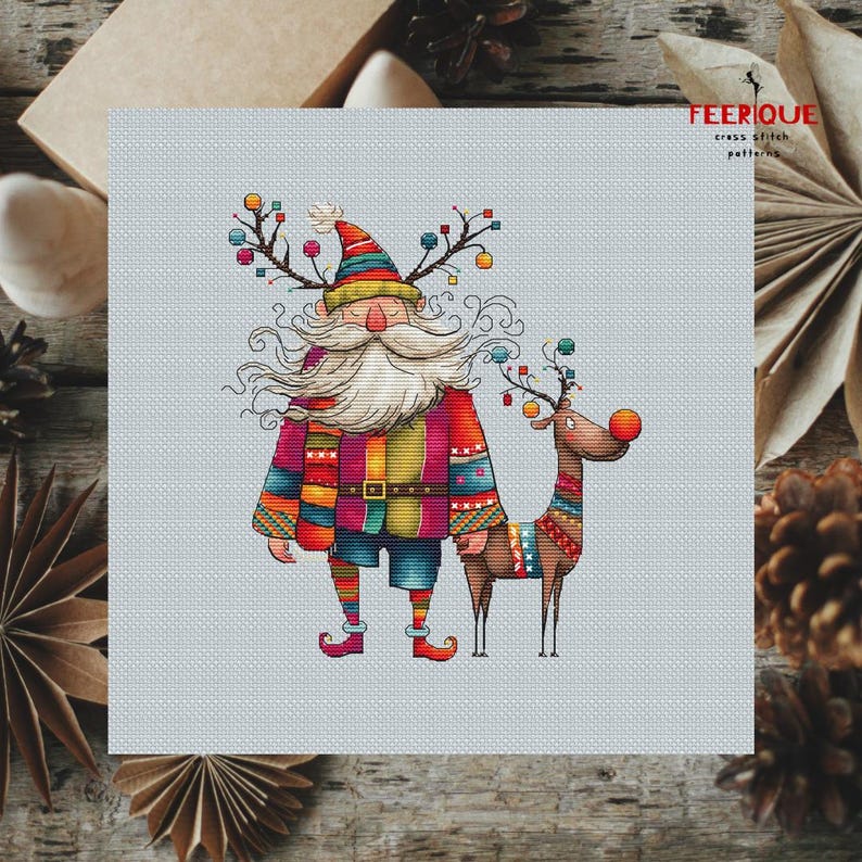 K&ouml;nnte beinhalten: Ein farbenfrohes Kreuzstichmuster mit einem skurrilen Weihnachtsmann mit langem wei&szlig;em Bart und einem Rentier mit roter Nase. Der Weihnachtsmann tr&auml;gt einen rot-gr&uuml;n-gelb-blau gestreiften Pullover und eine blaue Hose. Das Rentier tr&auml;gt einen bunten gestreiften Pullover. Das Muster ist auf einem hellblauen Hintergrund.