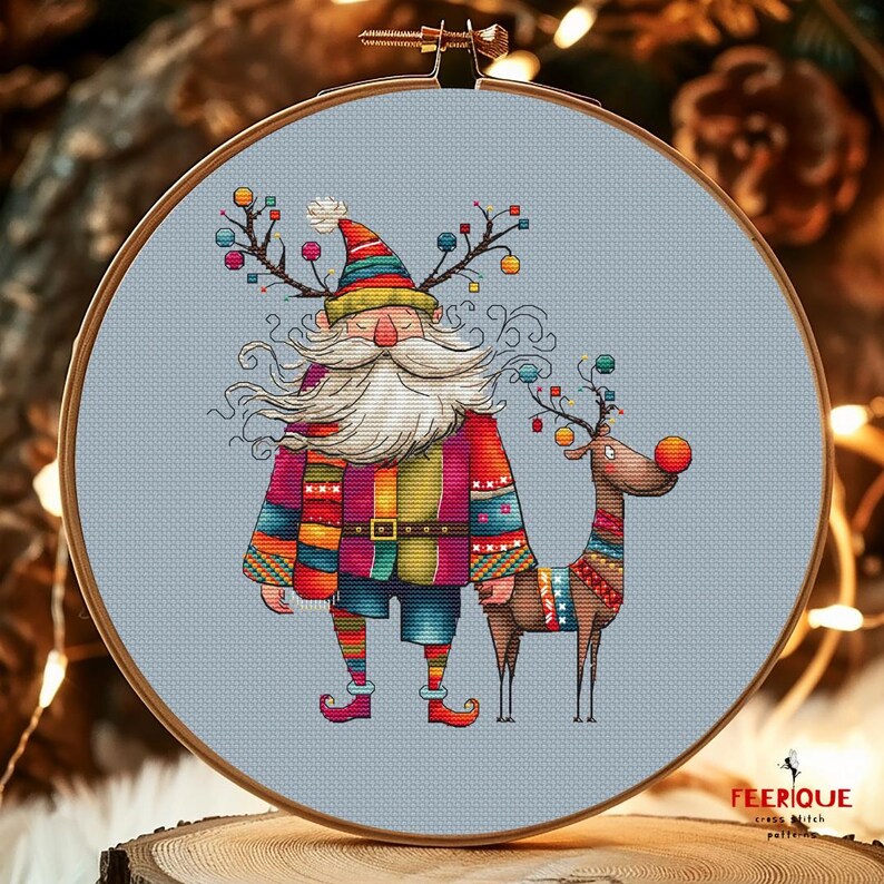 K&ouml;nnte beinhalten: Ein farbenfrohes Kreuzstichmuster mit einem skurrilen Weihnachtsmann mit langem wei&szlig;em Bart und einem Rentier mit roter Nase. Der Weihnachtsmann tr&auml;gt einen bunten gestreiften Pullover und Hut, und das Rentier tr&auml;gt einen bunten gestreiften Pullover. Das Muster ist auf einem hellblauen Hintergrund.
