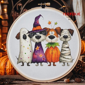 Puede incluir: Un patr&oacute;n de punto de cruz en un aro de madera muestra cuatro perros disfrazados para Halloween: un fantasma, una bruja, una calabaza y una momia. El texto "FEERIQUE cross stitch patterns" es visible. El dise&ntilde;o est&aacute; sobre tela blanca.
