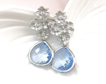 May include: Silver floral dangle earrings with light blue teardrop-shaped crystals.