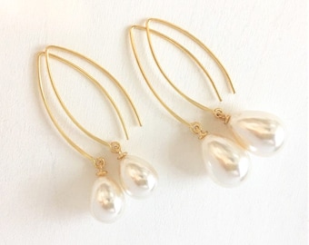 May include: A pair of gold dangle earrings with two white pearl drops on each earring.