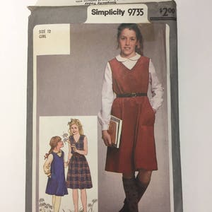 May include: Simplicity sewing pattern 9735 for a girl's dress. The pattern includes a red dress with a white collar and a plaid dress. The pattern is for size 12 and costs $2.00.