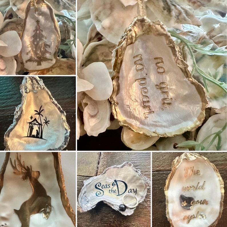 May include: A collection of oyster shells with various designs and sayings. The shells are painted gold and white and feature designs such as a Christmas tree, a nativity scene, a deer, and the phrase "Seas the Day". One shell has the saying "No grit, no pearl".