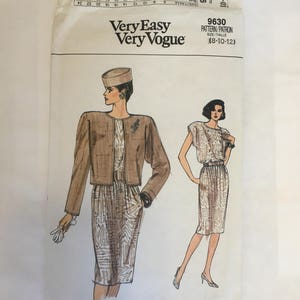 May include: A sewing pattern for a dress and jacket. The pattern is for sizes 8-10-12. The pattern is called "Very Easy Very Vogue" and the pattern number is 9630. The pattern shows a woman wearing a brown and white patterned dress and jacket with a brown belt. The woman is wearing a brown hat.