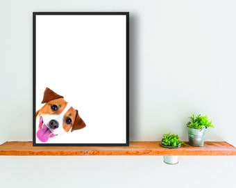 May include: A framed print of a dog's head peeking out from the corner of the frame. The dog has brown and white fur and is smiling with its tongue sticking out.