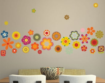 Puede incluir: Una calcomanía de pared con una variedad de flores coloridas en un estilo retro. Las flores están dispuestas en una línea curva a través de la pared, con algunas flores dispersas arriba. Las flores son en tonos de naranja, amarillo, rojo, rosa, verde y azul.