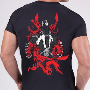 May include: Black t-shirt with a red and white graphic print of a superhero character with a skull on its chest and a red cape.