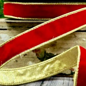May include: Red velvet ribbon with a gold metallic border. The ribbon is curled and layered, showcasing the rich red color and the shimmering gold edge. Ideal for crafts and holiday decorations.