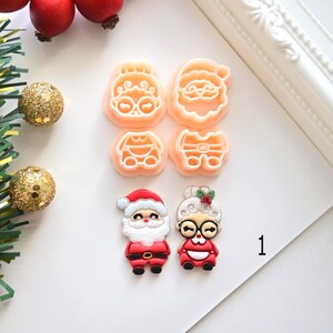 K&ouml;nnte beinhalten: Eine Sammlung von weihnachtlichen Ausstechformen und dekorativen Figuren. Die Ausstecher haben die Form von Weihnachtsmann und Frau Claus. Die Figuren zeigen Weihnachtsmann und Frau Claus in rot-wei&szlig;en Outfits. Die Zahl 1 befindet sich im Bild.
