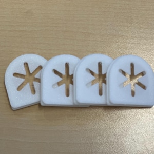 May include: Four white foam earplugs with a star-shaped cutout. The earplugs are designed to reduce noise.