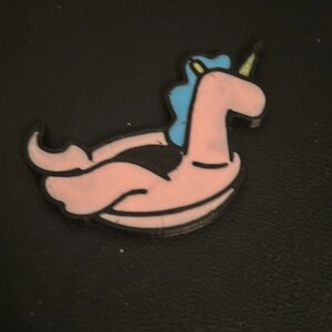 May include: A pink inflatable unicorn pool float with a blue mane and a yellow horn.