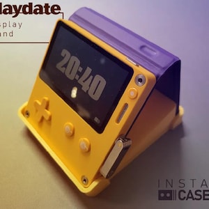 May include: A yellow and purple display stand for a handheld video game console. The console has a screen displaying the time 20:40. The stand is labeled "Playdate Display Stand" and "Instant Cassette".