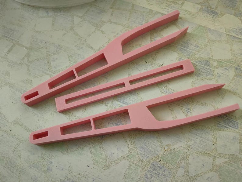 May include: Three pink plastic tweezers with different designs. The tweezers are used for crafts, hobbies, and other tasks.