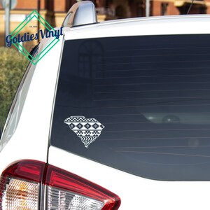 May include: A white vinyl decal of the South Carolina state outline, filled with a geometric pattern. The decal is affixed to the rear window of a white vehicle. The decal is from Goldies Vinyl.
